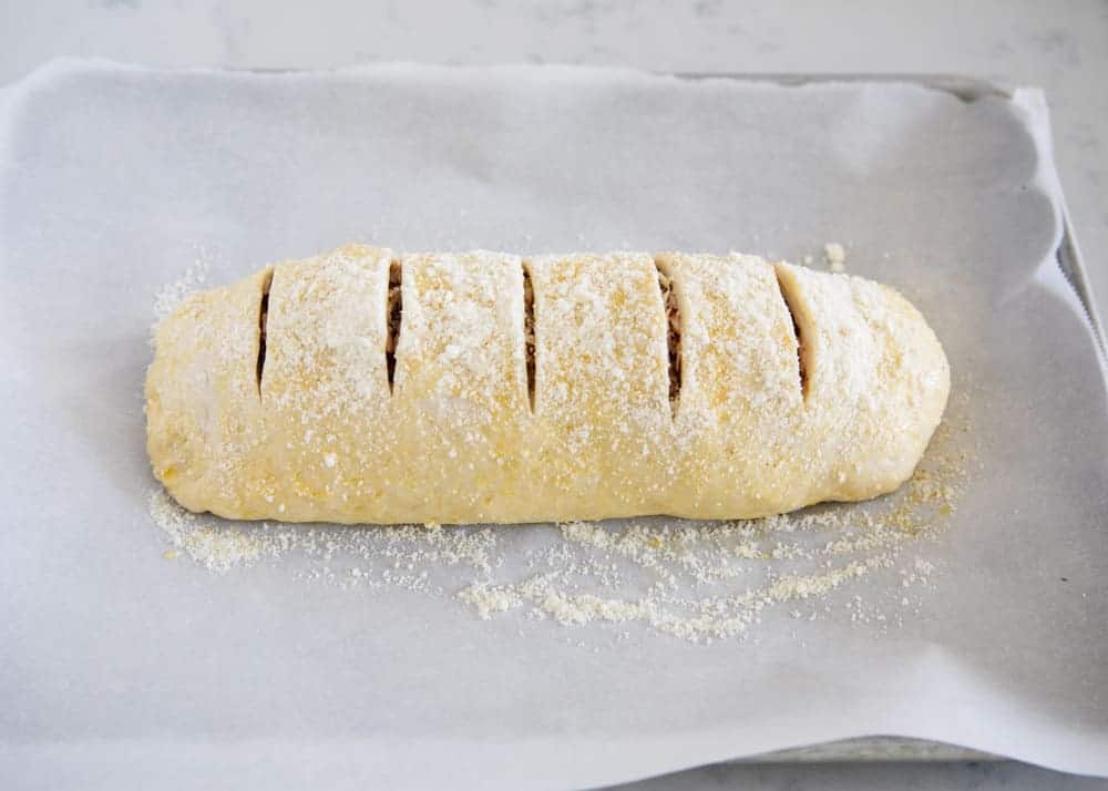 Rolled up stromboli with slits on the top to let steam escape.