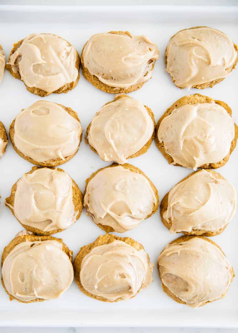 Iced pumpkin cookies on a plate.