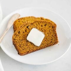 The best pumpkin bread sliced on a plate with butter.