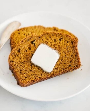 The best pumpkin bread sliced on a plate with butter.