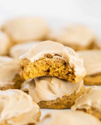 iced pumpkin cookies with a bite taken