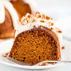 piece of pumpkin bundt cake on a white plate with a fork
