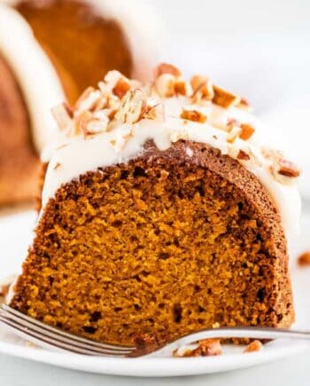 piece of pumpkin bundt cake on a white plate with a fork