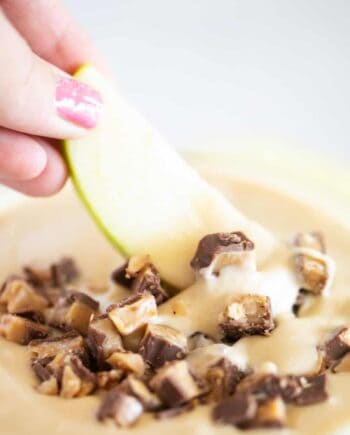 dipping an apple into toffee caramel dip