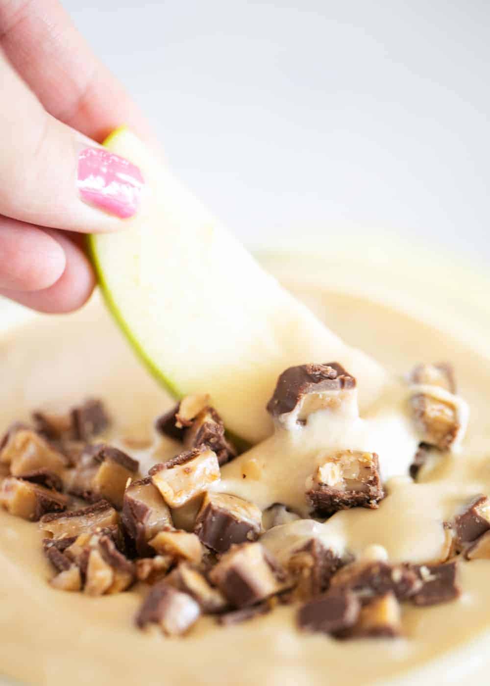 Dipping an apple into toffee caramel dip.