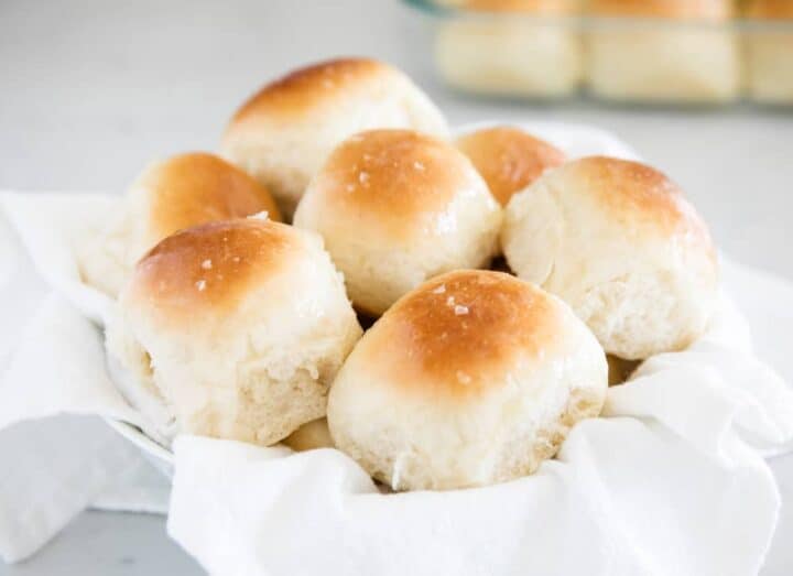 dinner rolls in basket with white towel