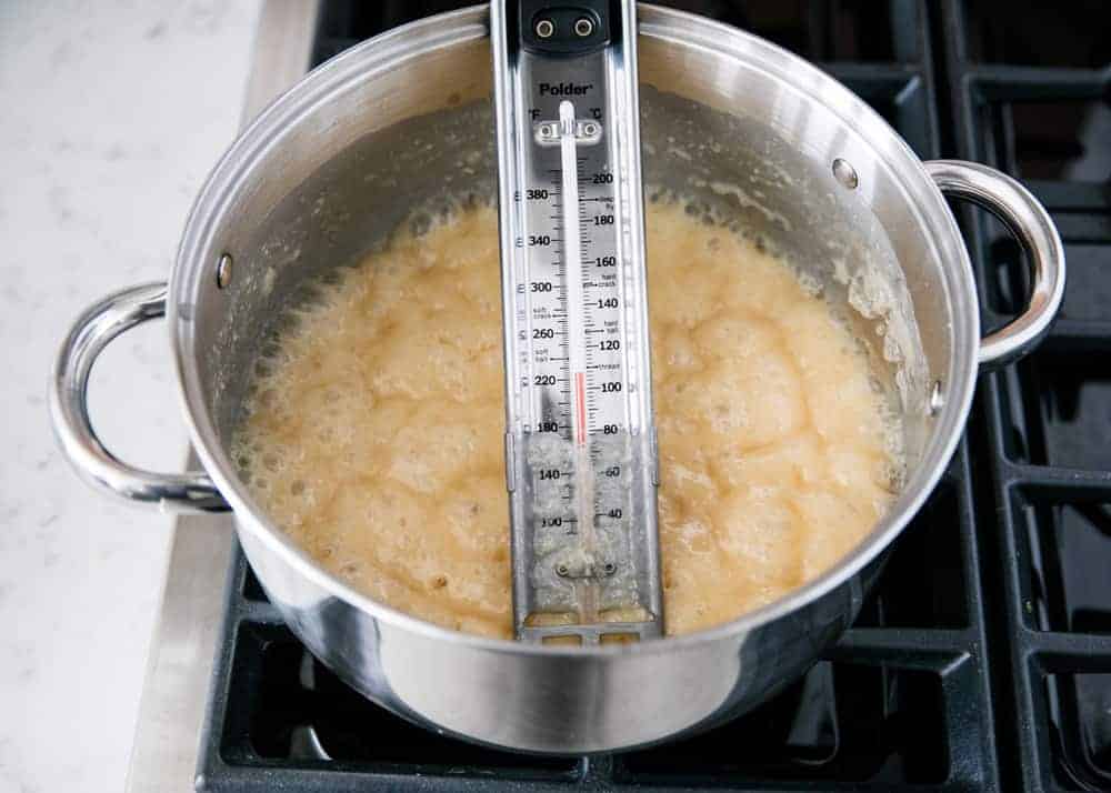 testing homemade caramel with a candy thermometer 