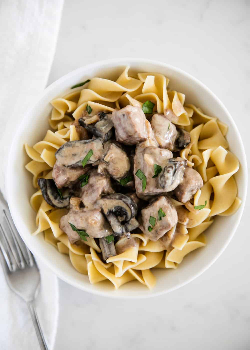 Bowl of beef stroganoff served over egg noodles.