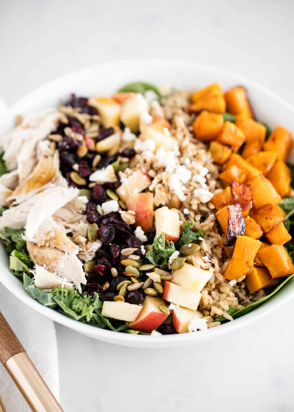 Fall salad in a white bowl.