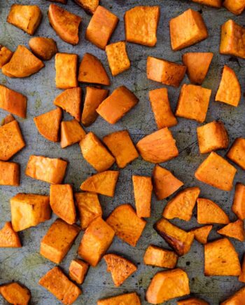 close up of roasted sweet potatoes on baking sheet