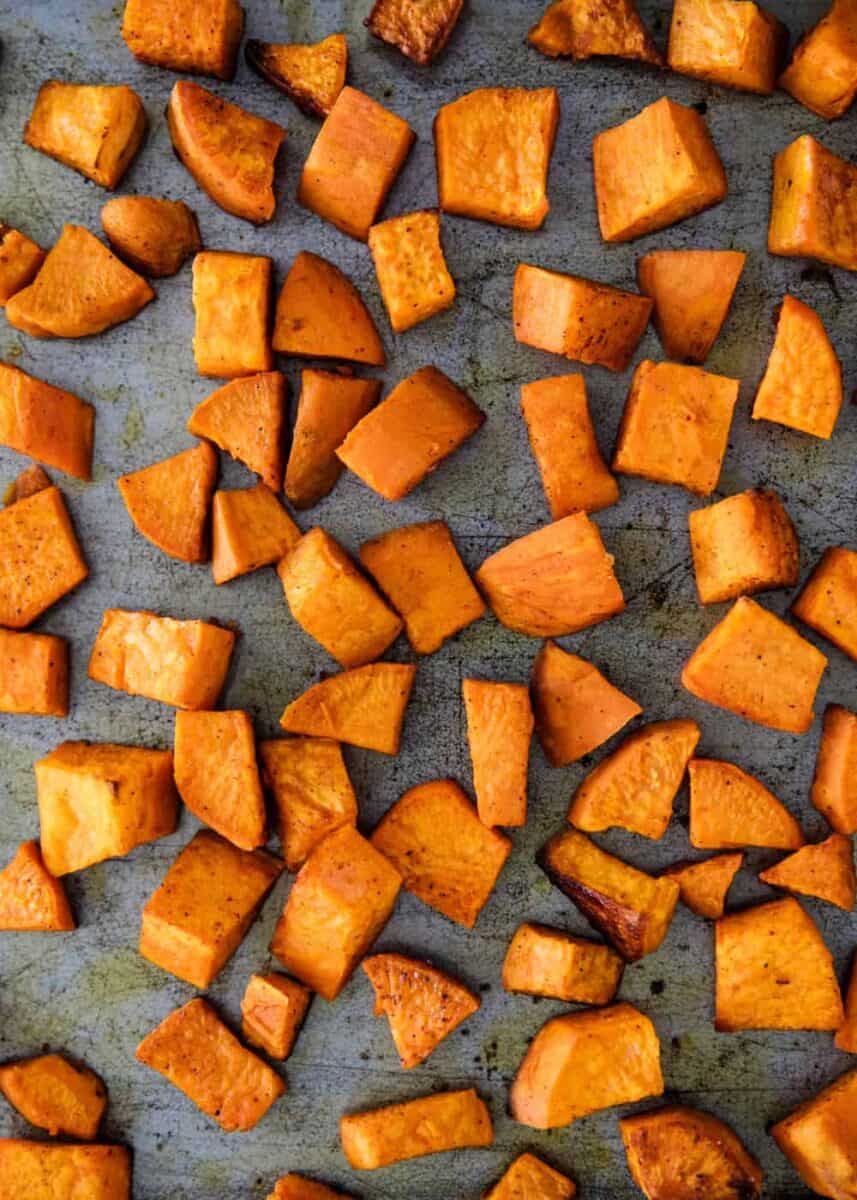 close up of roasted sweet potatoes on baking sheet 