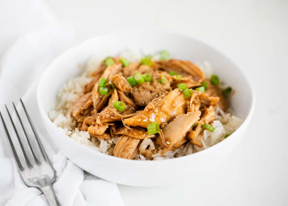 This easy crock pot teriyaki chicken is a family favorite with only 5 minutes prep. A homemade teriyaki sauce slow cooks with chicken breasts for a flavorful weeknight meal. Teriyaki chicken with rice in bowl.