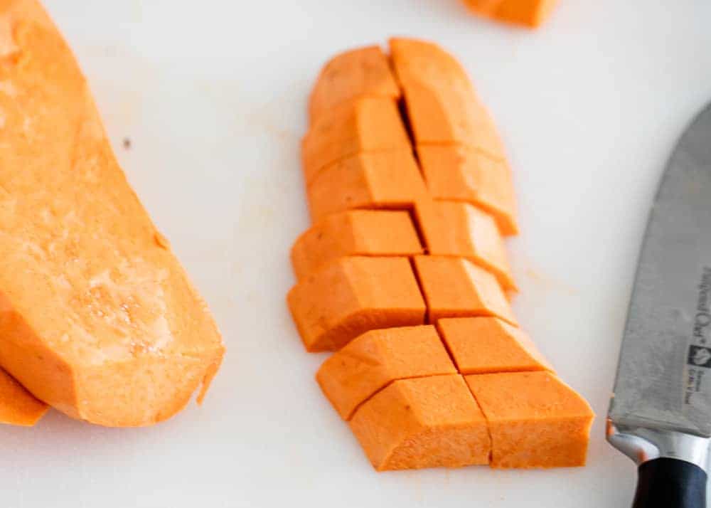 Cutting sweet potatoes into cubes.