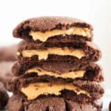 stack of chocolate peanut butter stuffed cookies with peanut butter filling oozing out