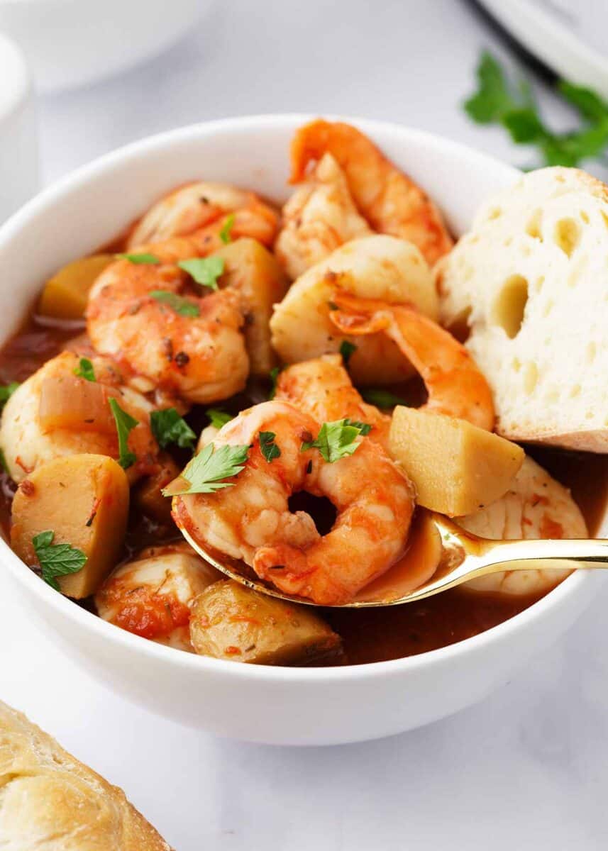 Seafood stew in a white bowl.