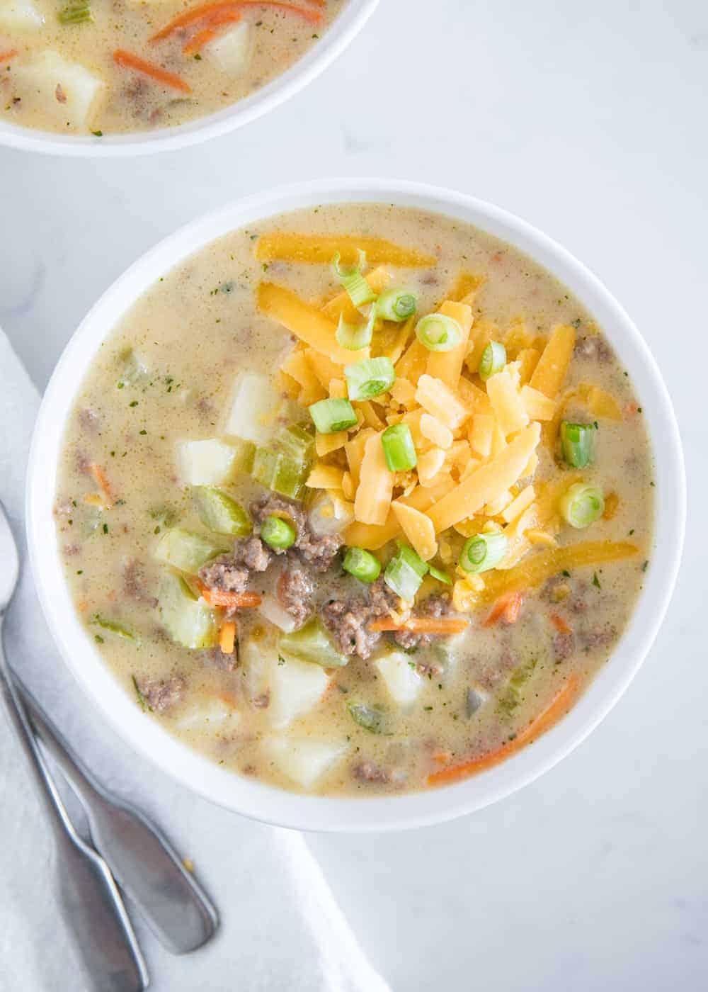 Cheeseburger soup in white bowl.