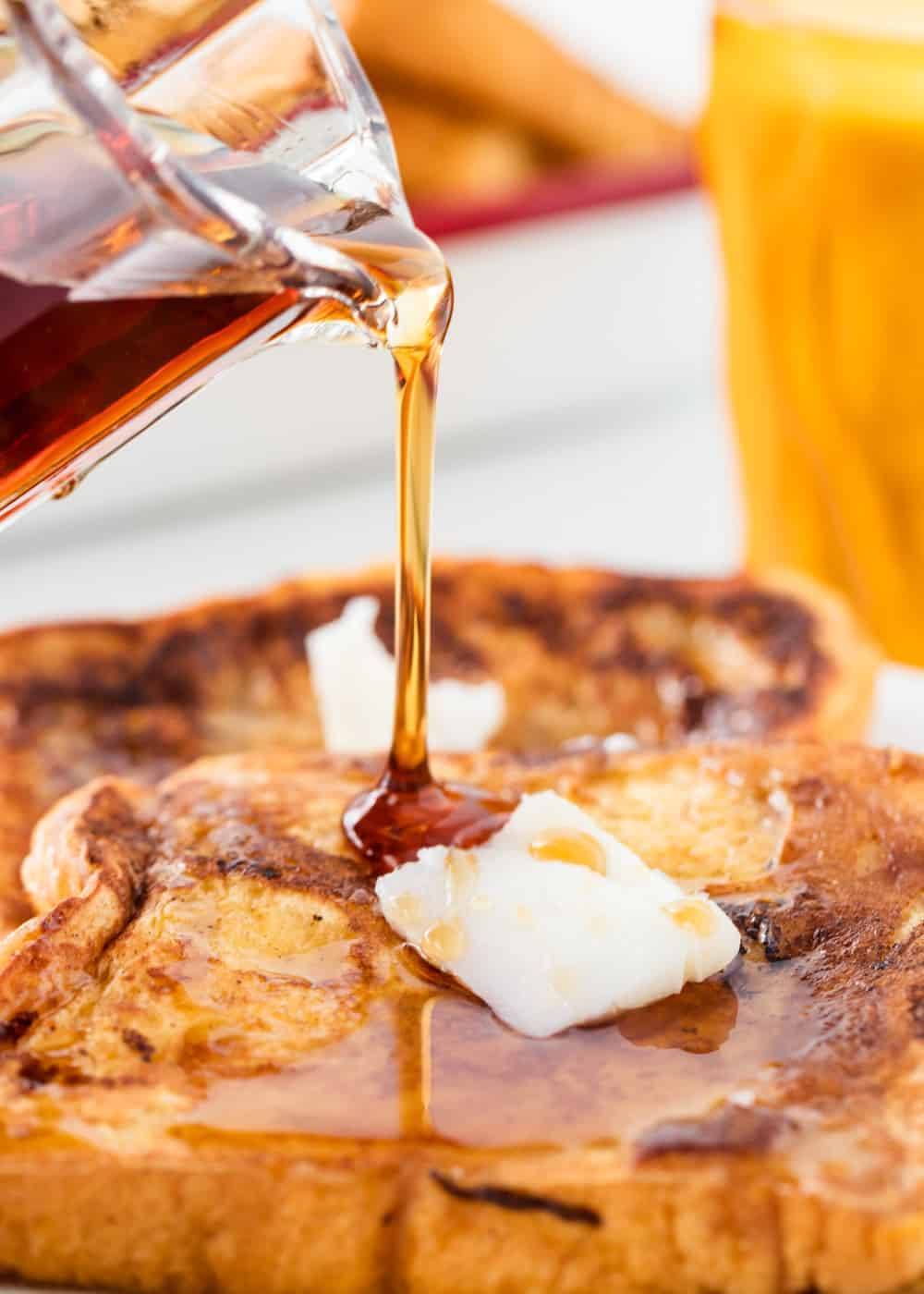 Pouring syrup on top of eggnog french toast.