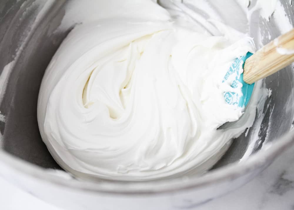 Mixing together royal icing in a bowl.