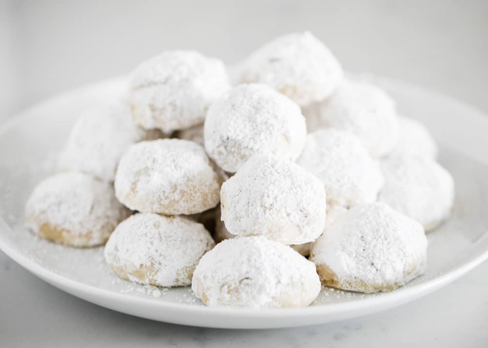 Mexican wedding cookies on white plate.