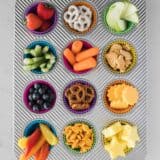 muffin tin filled with different types of snacks in each muffin cup