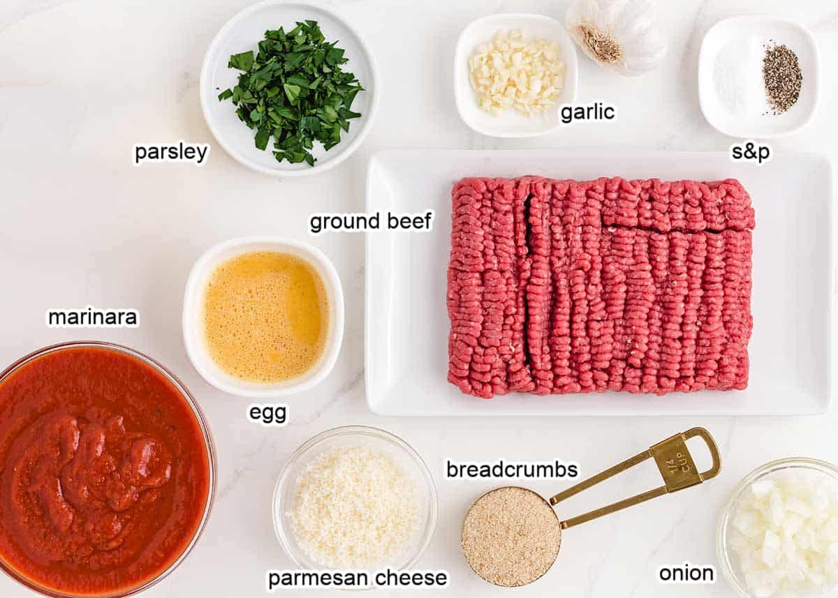 Homemade meatball ingredients on a marble countertop. 