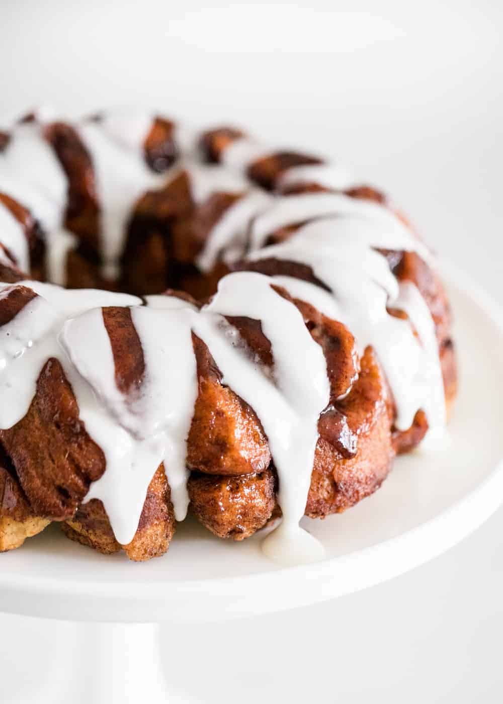 Frosted cinnamon roll monkey bread on a cake stand.