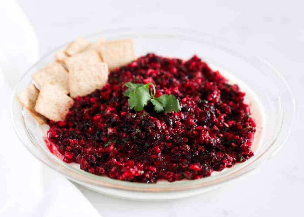 Cranberry salsa in glass dish with crackers.