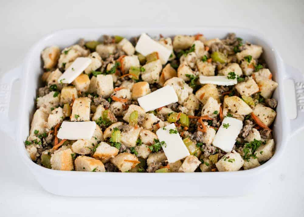 Stuffing in white casserole dish with butter on top.