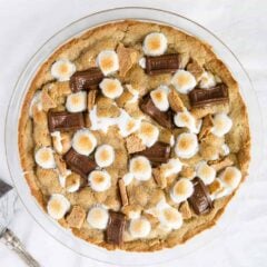 Golden-brown s’mores pie with toasted marshmallows on top, baked in a glass pie dish.