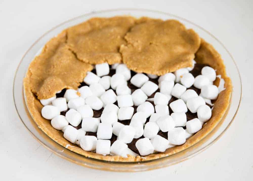 Adding crust on top of s'mores pie.