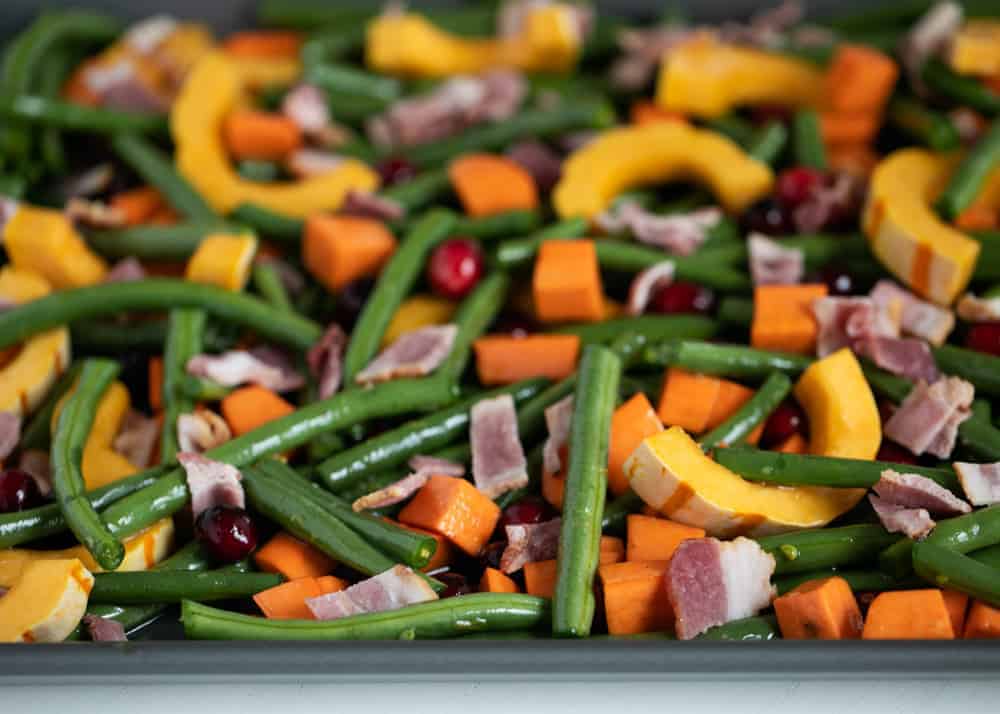 Vegetables on pan with maple syrup and bacon.