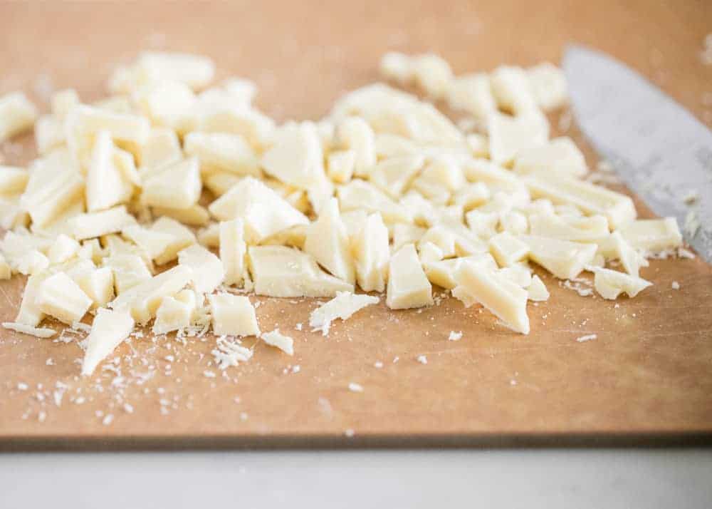 Chopped white chocolate on a cutting board.