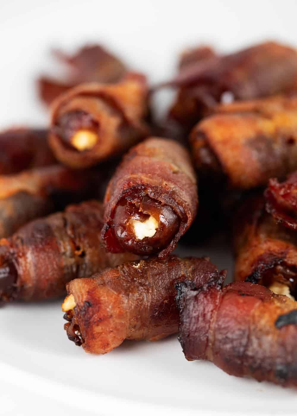 Bacon-wrapped dates on a plate.