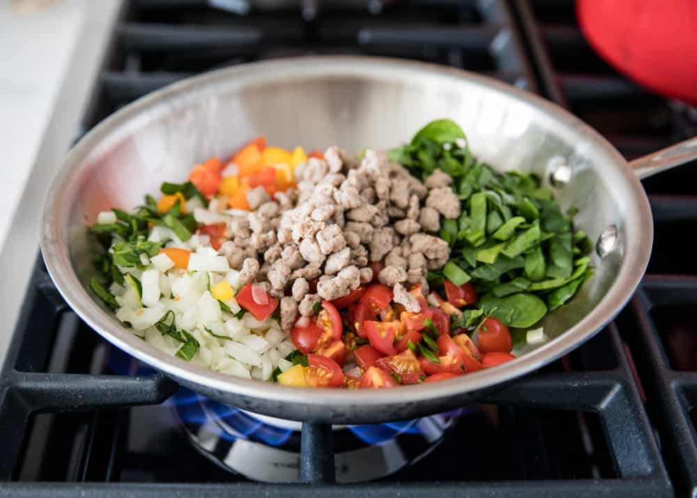 Cooking the meat and veggies for egg white muffins in a pan on the stove.