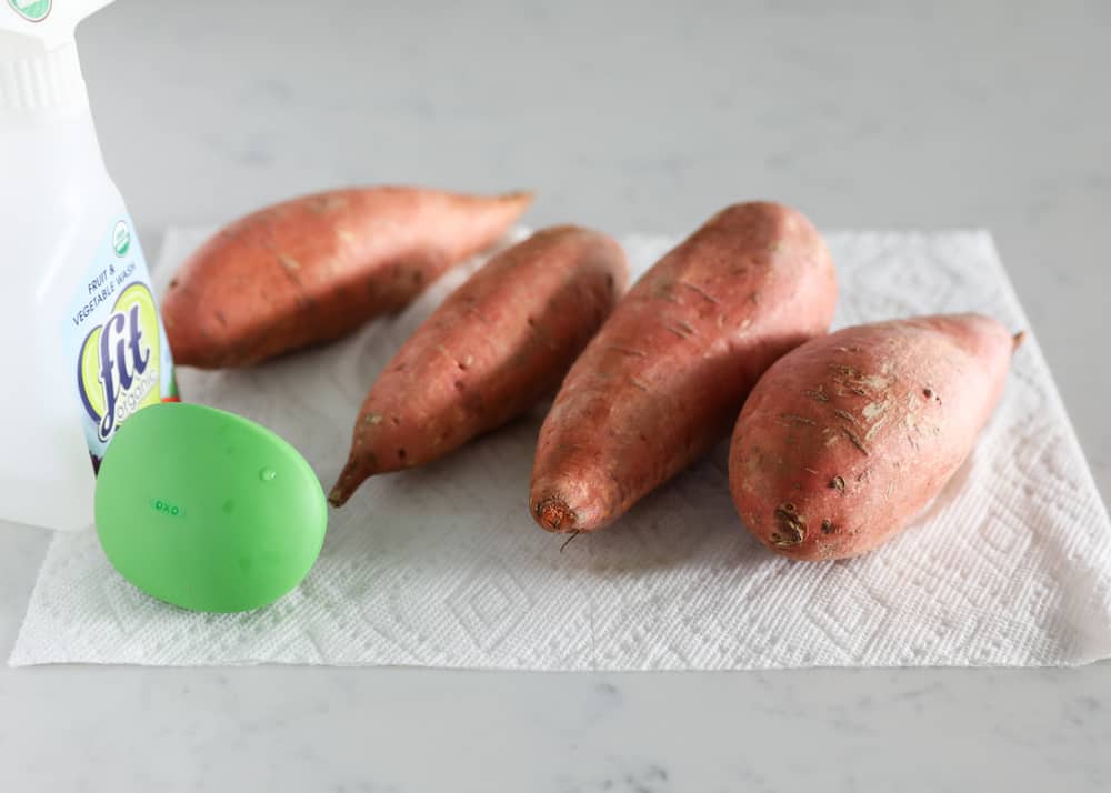 Washed and scrubbed sweet potatoes laying on paper towel.