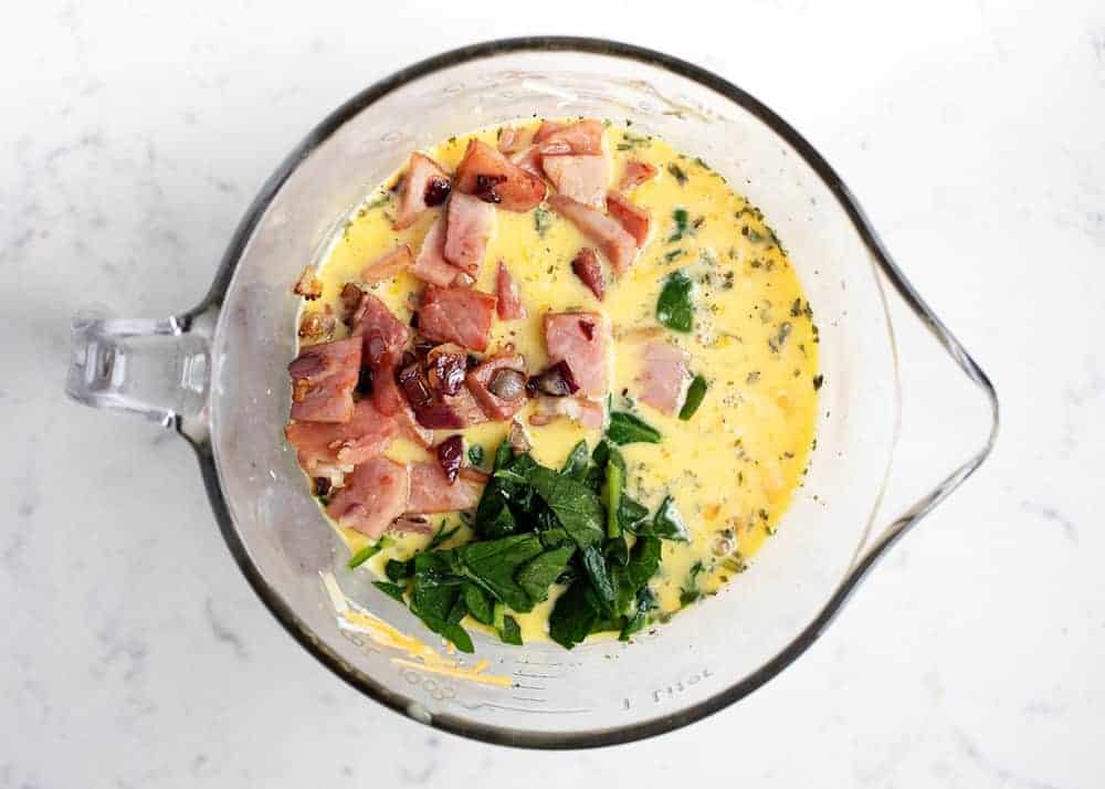 Filling for ham and cheese quiche in a measuring bowl.