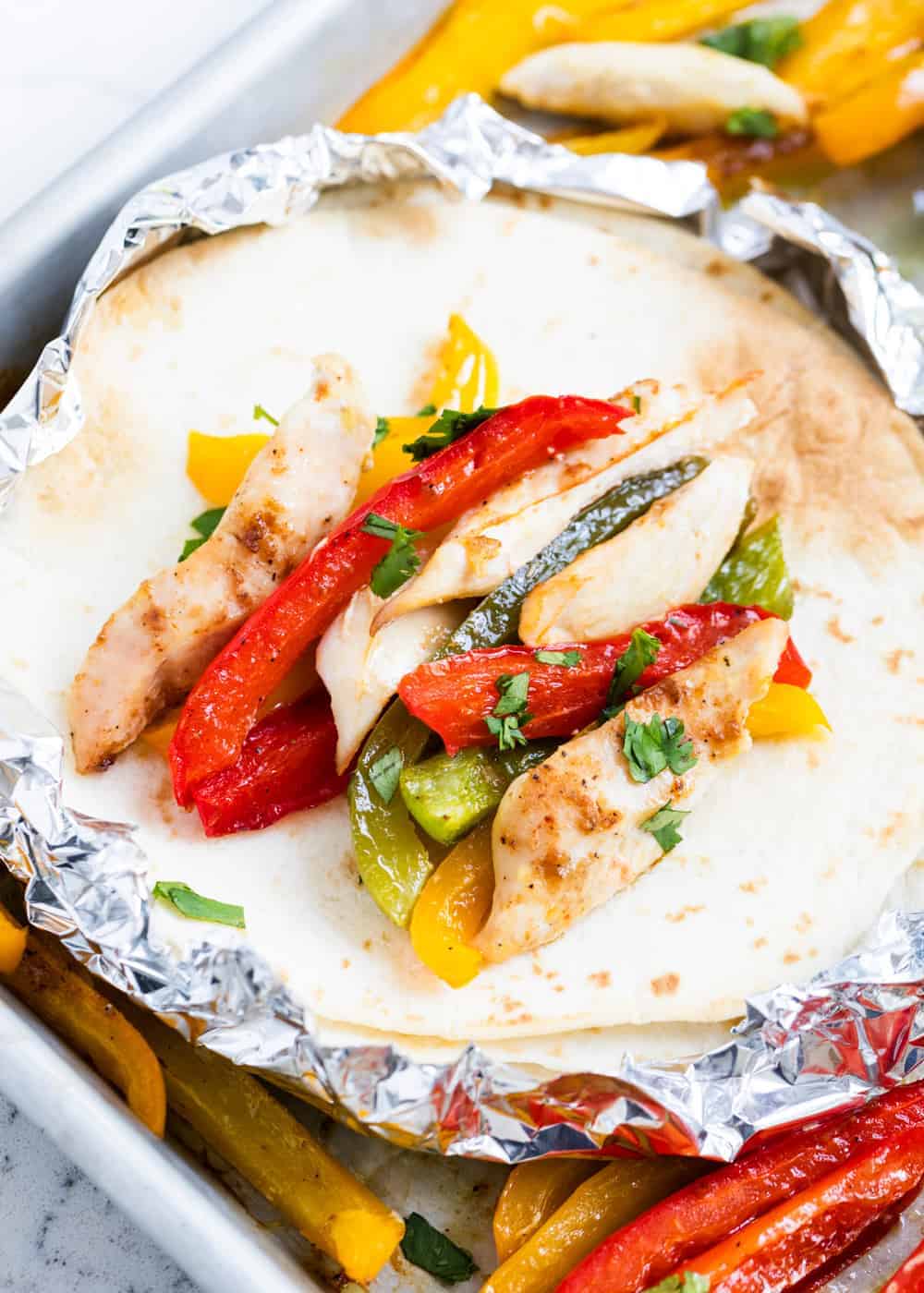 Chicken fajitas on a flour tortilla.