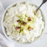 snicker apple salad in white bowl with spoon