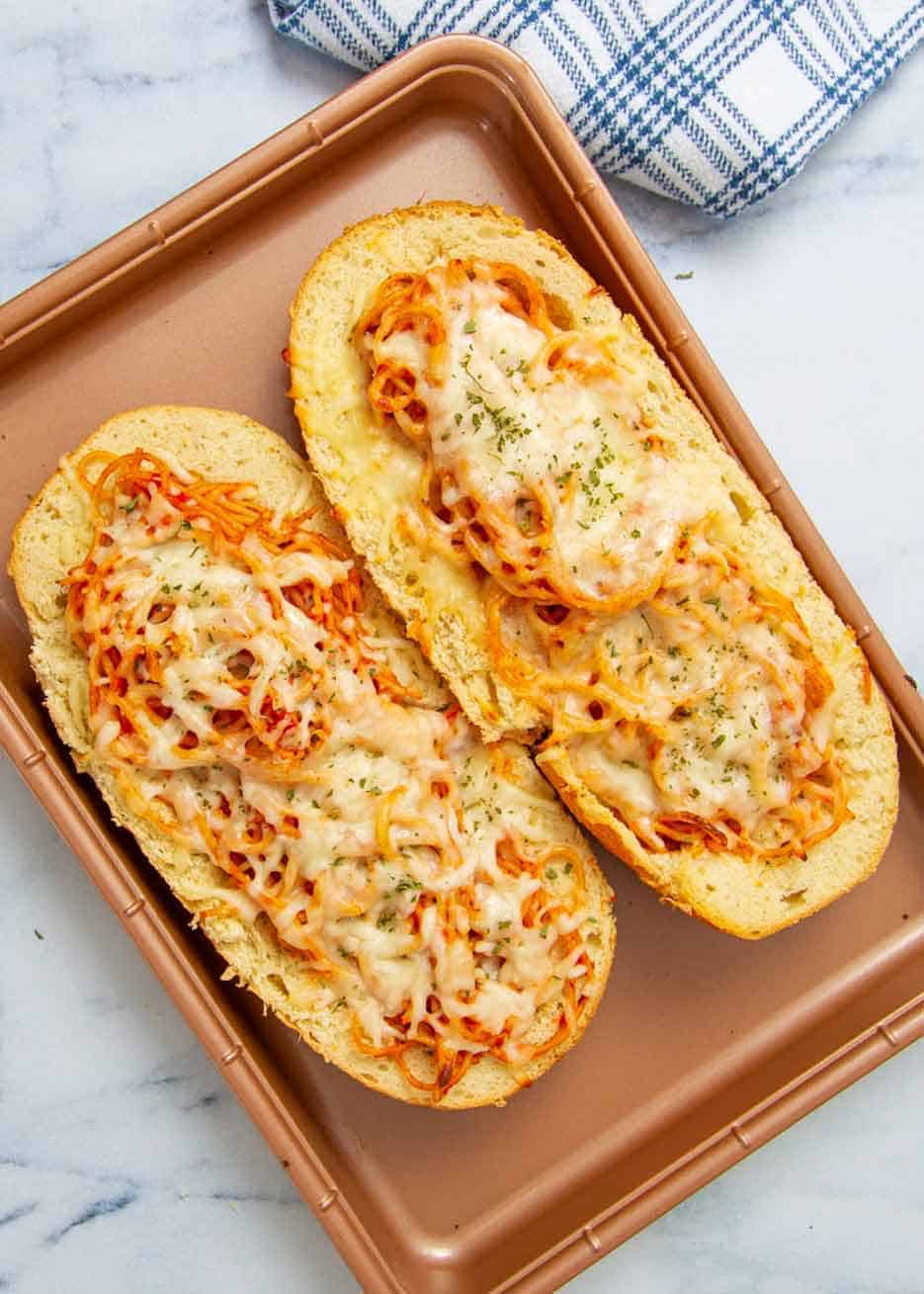 Spaghetti boats on baking sheet.