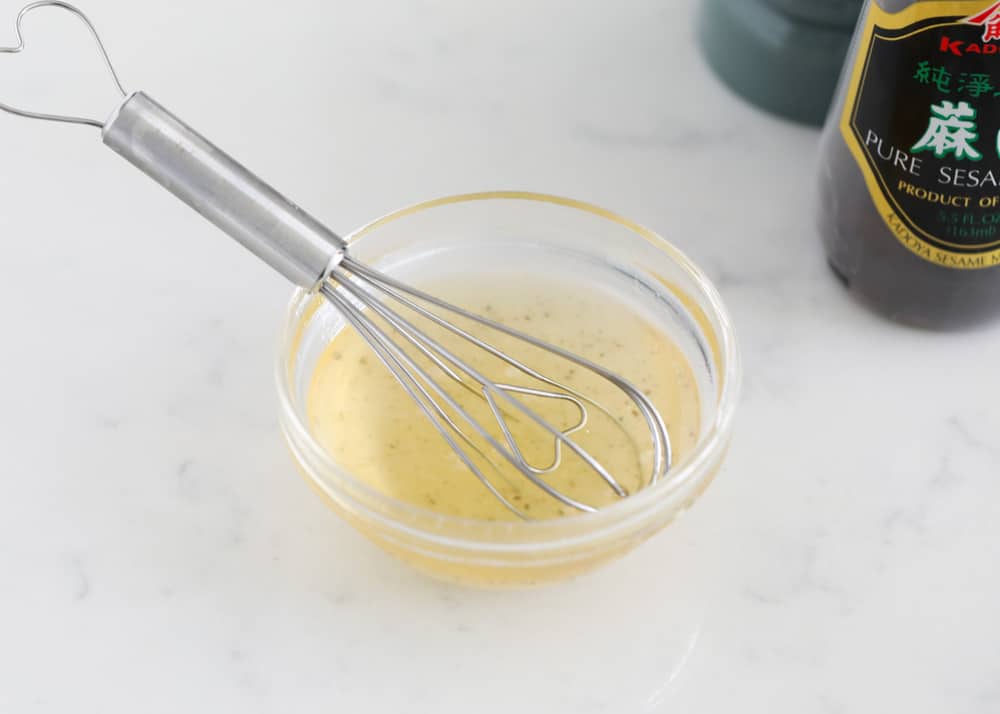 Asian chicken salad dressing in glass bowl.