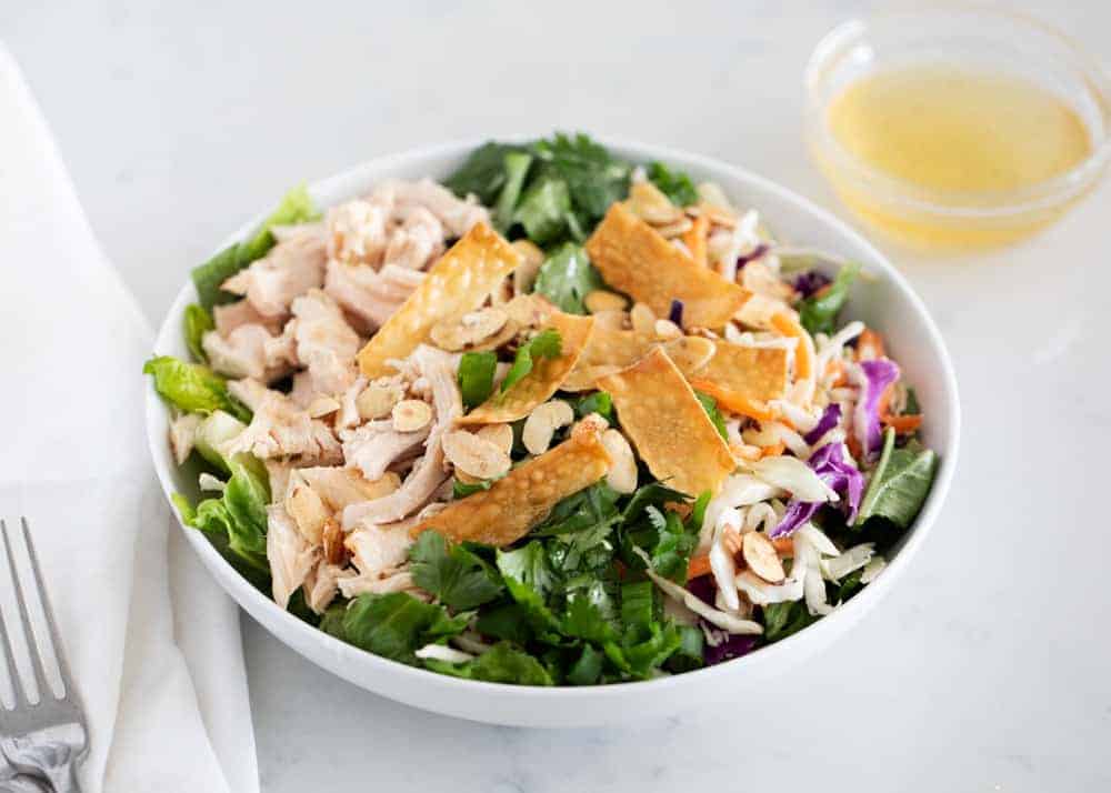 Asian chicken salad in a white bowl.