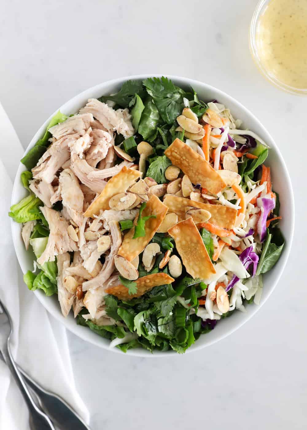 Asian chicken salad in white bowl.