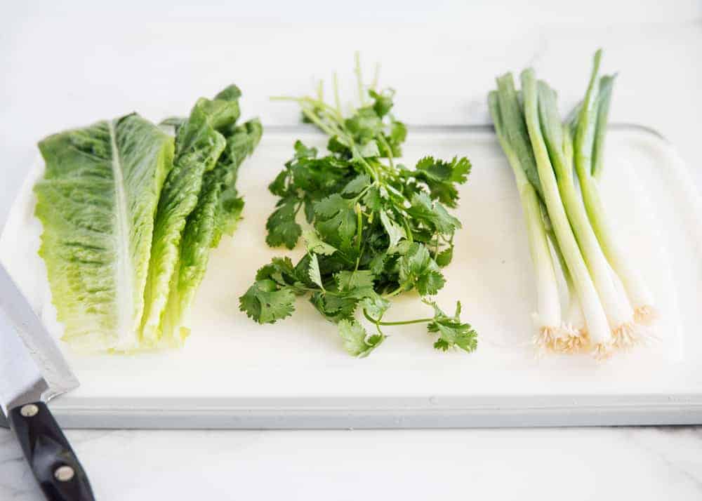 Salad greens on cutting board.