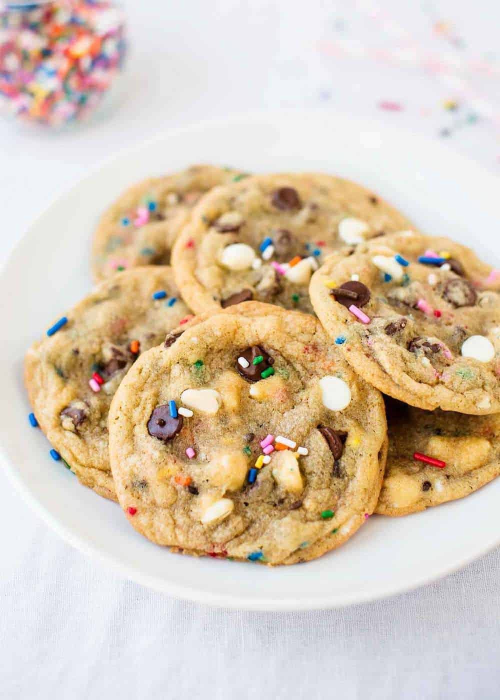 Birthday chocolate chip cookies with sprinkles on a white plate.