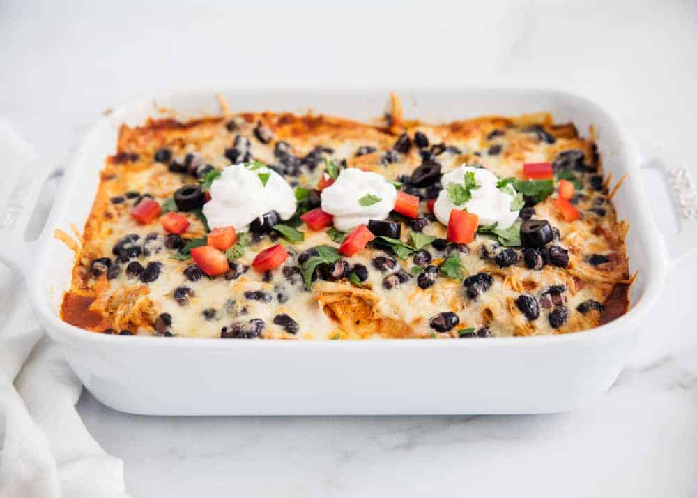 Chicken enchilada casserole in white dish.