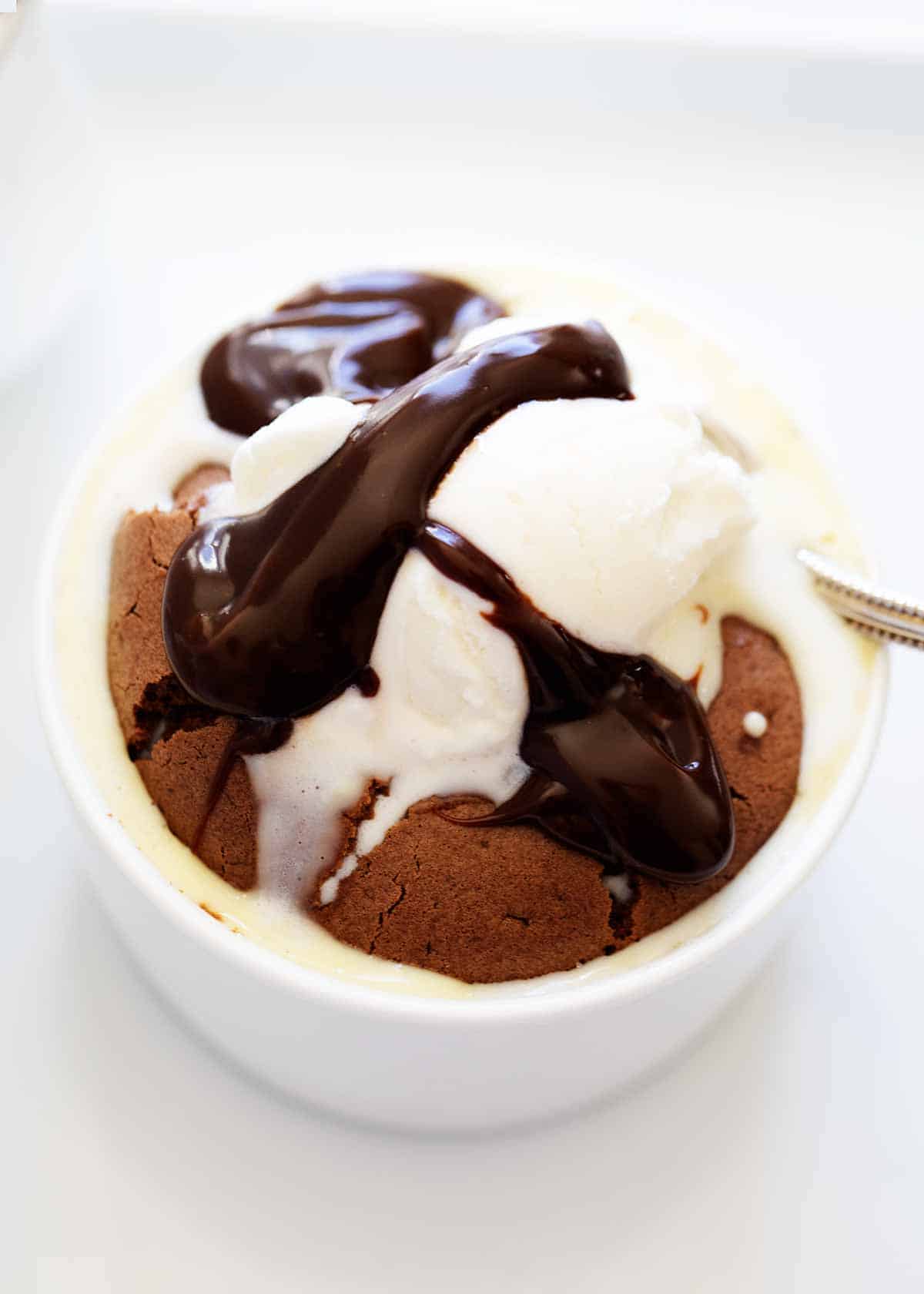 Chocolate souffle ramekin with vanilla ice cream and hot fudge sauce.