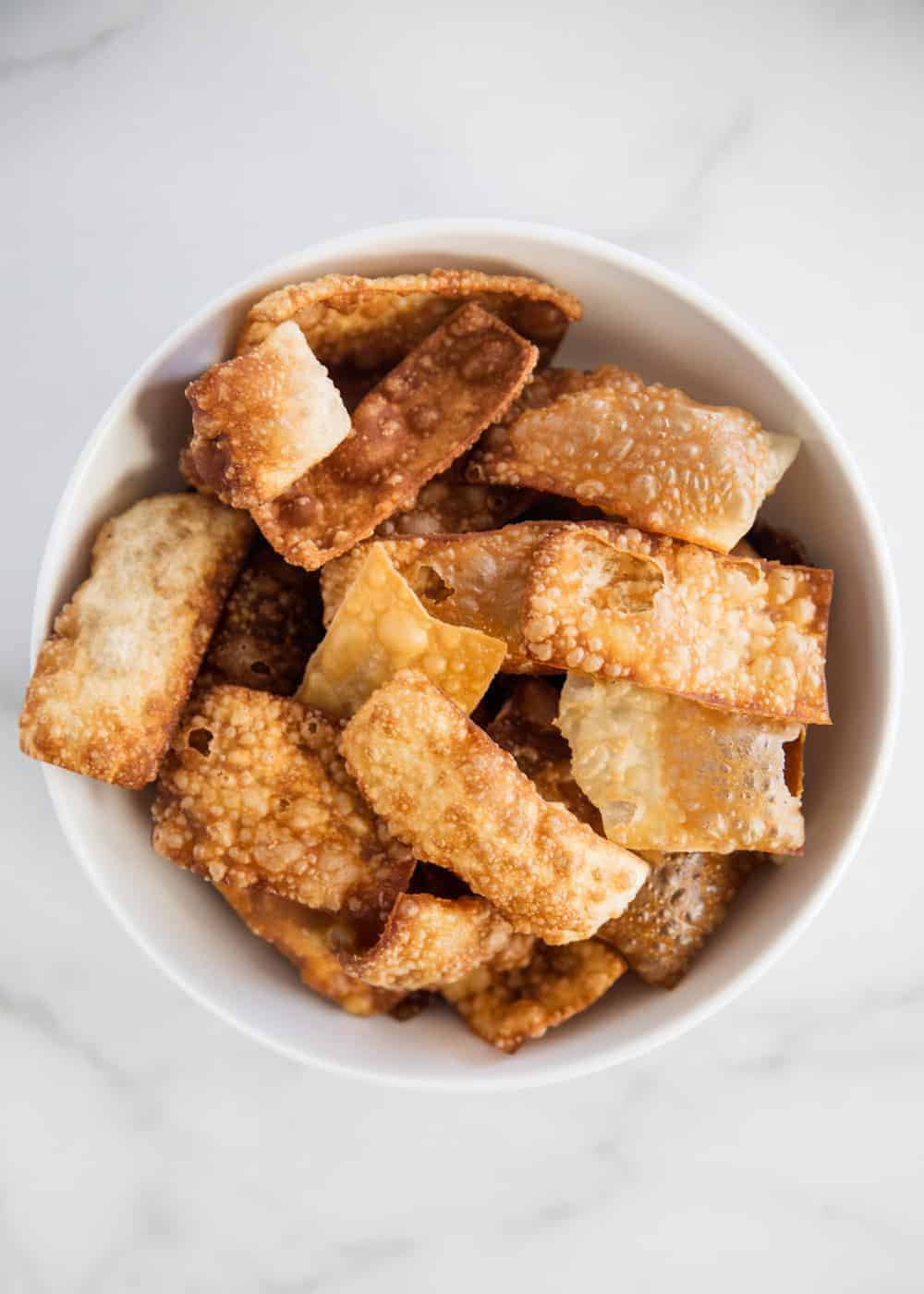 Wonton strips stacked in bowl.