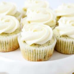 frosted lemon poppy seed cupcakes on a white cake stand