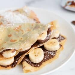 nutella crepes with bananas on white plate