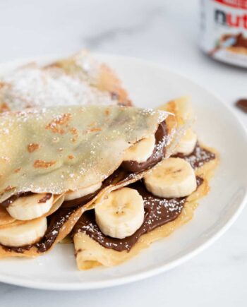 nutella crepes with bananas on white plate